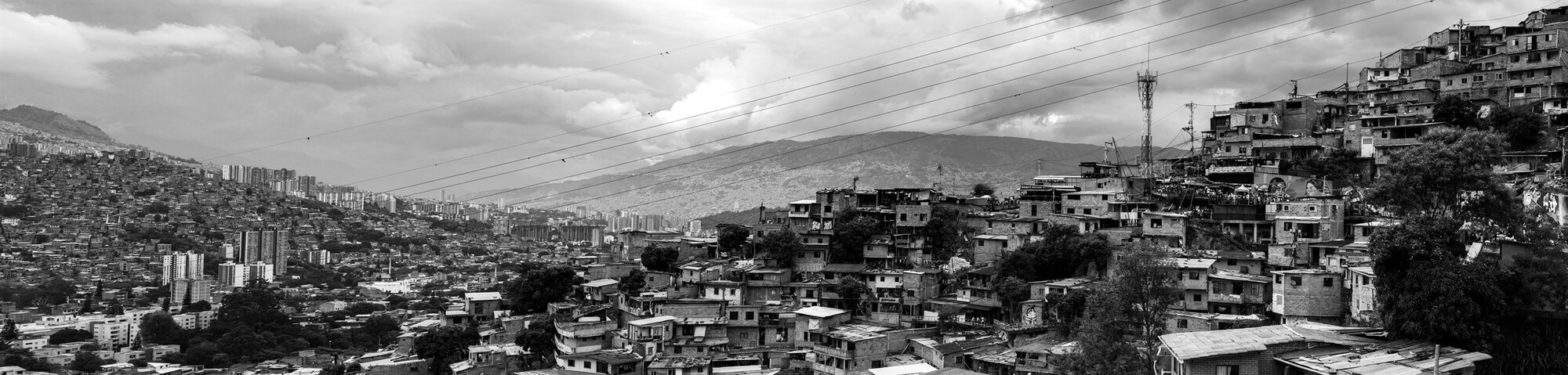 A hillside neighbourhood of Medellín stretching under cloud