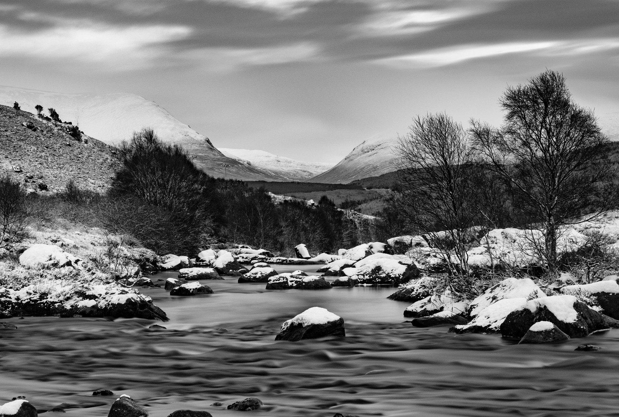 A snowy river running towards snow-covered mountains